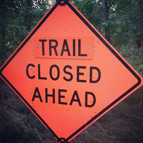 Warning sign stating Trail Closed Ahead