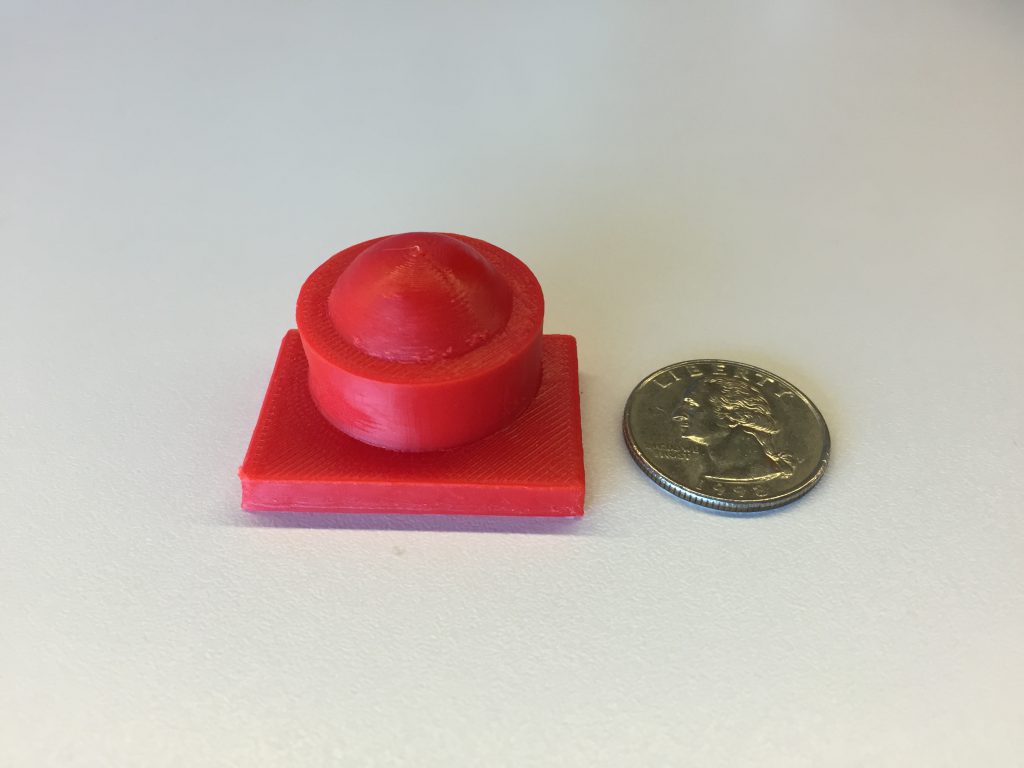 Image of a 3D-printed button next to a dime for comparison