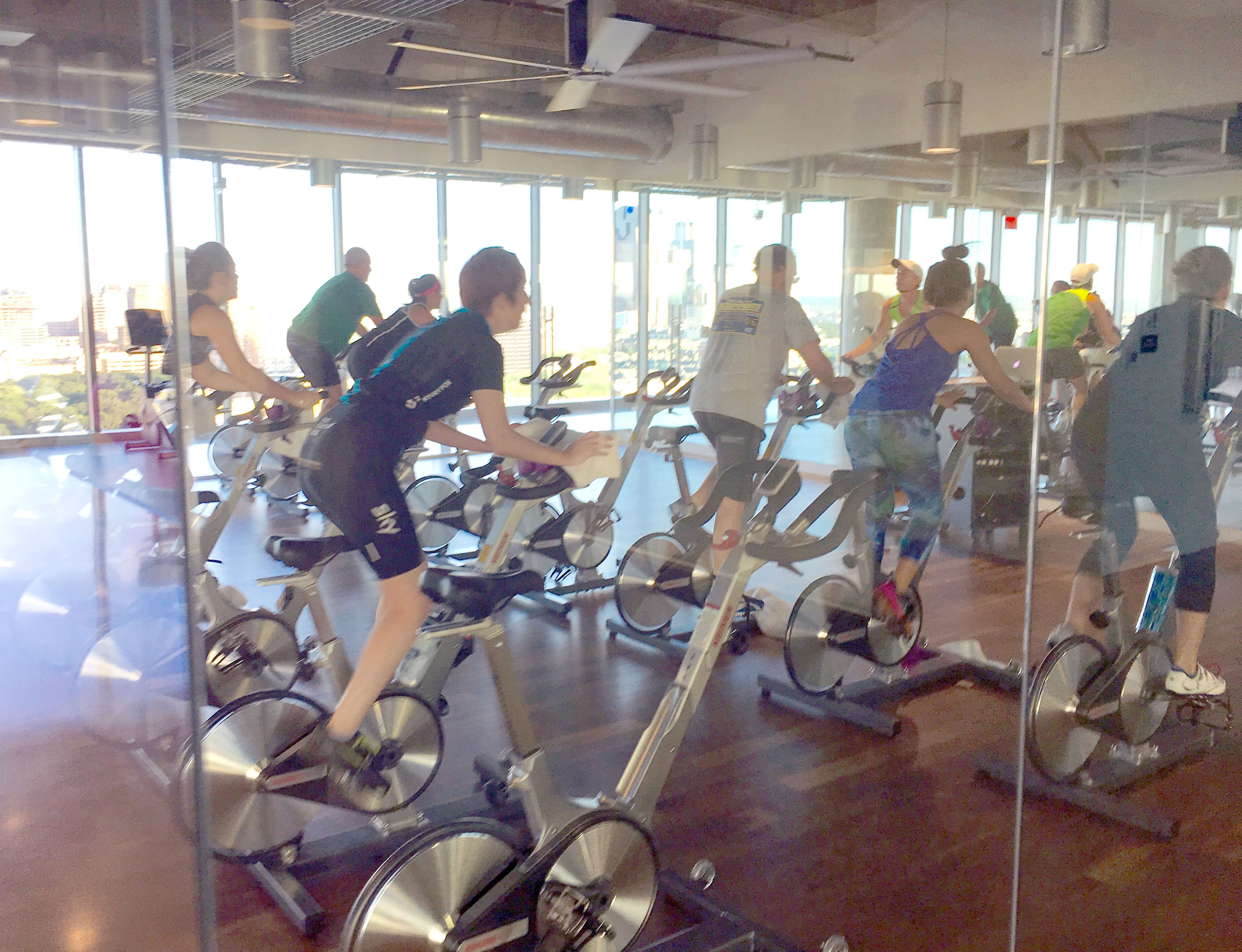 Photo of a group of people on stationary bikes participating in a Spin class.
