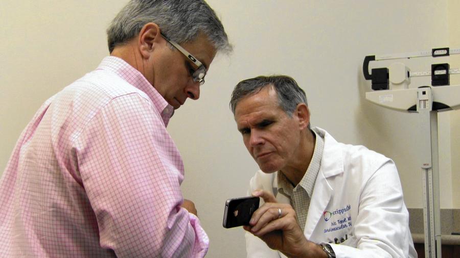 doctor showing results on health app to patient 