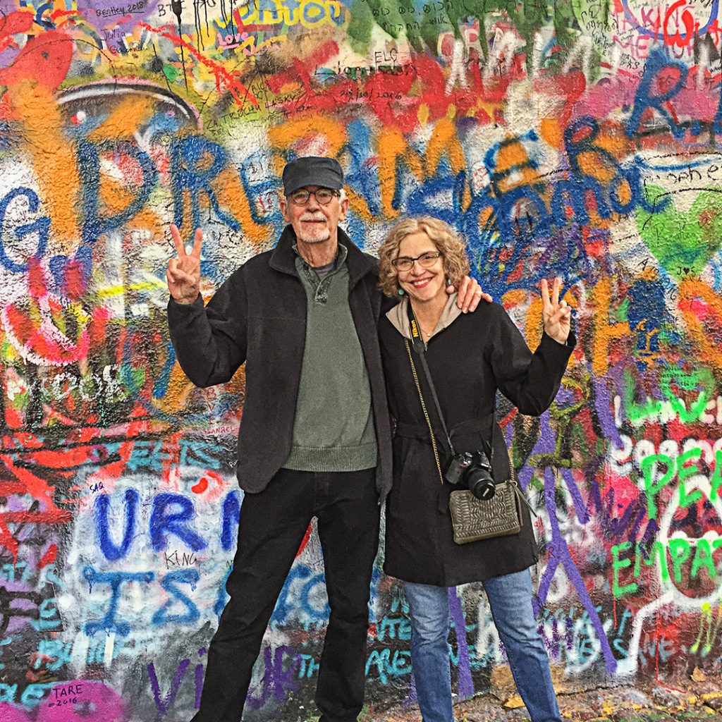 Nancy Hogan and her husband in front of a wall of graffiti